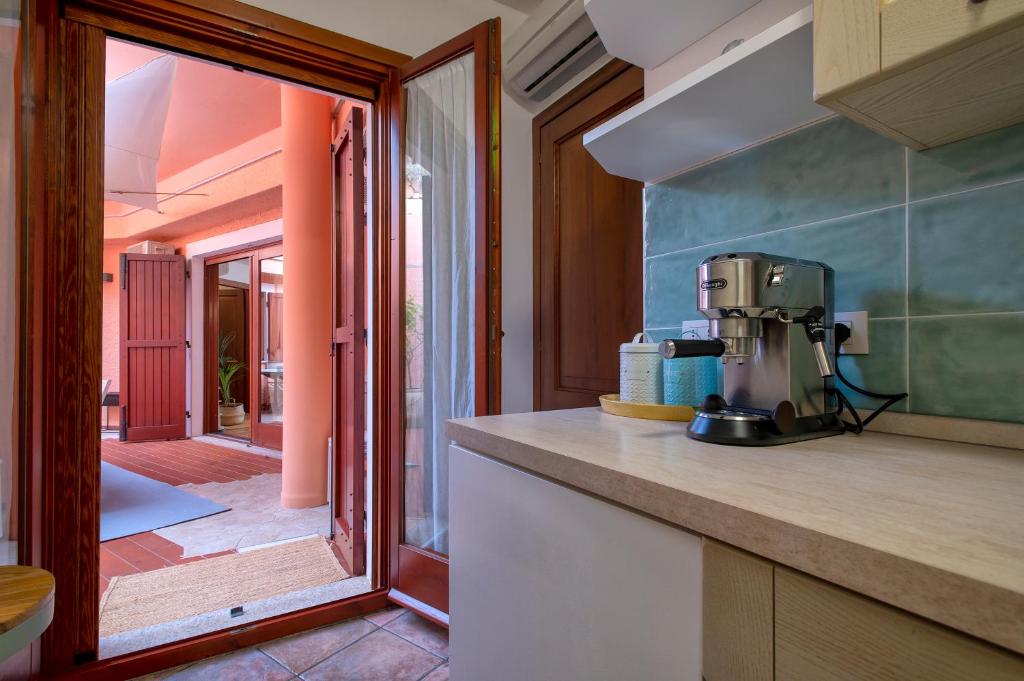 une cuisine avec un mixeur sur un comptoir à côté d'un patio dans l'établissement Villa Patty with infinity pool in front of the sea, parking and wifi, à Torre delle Stelle
