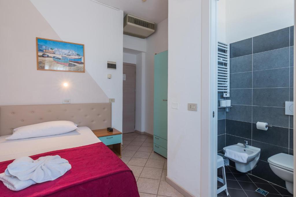 une chambre avec un lit et une salle de bain avec WC dans l'établissement Hotel Blumen, à Rimini