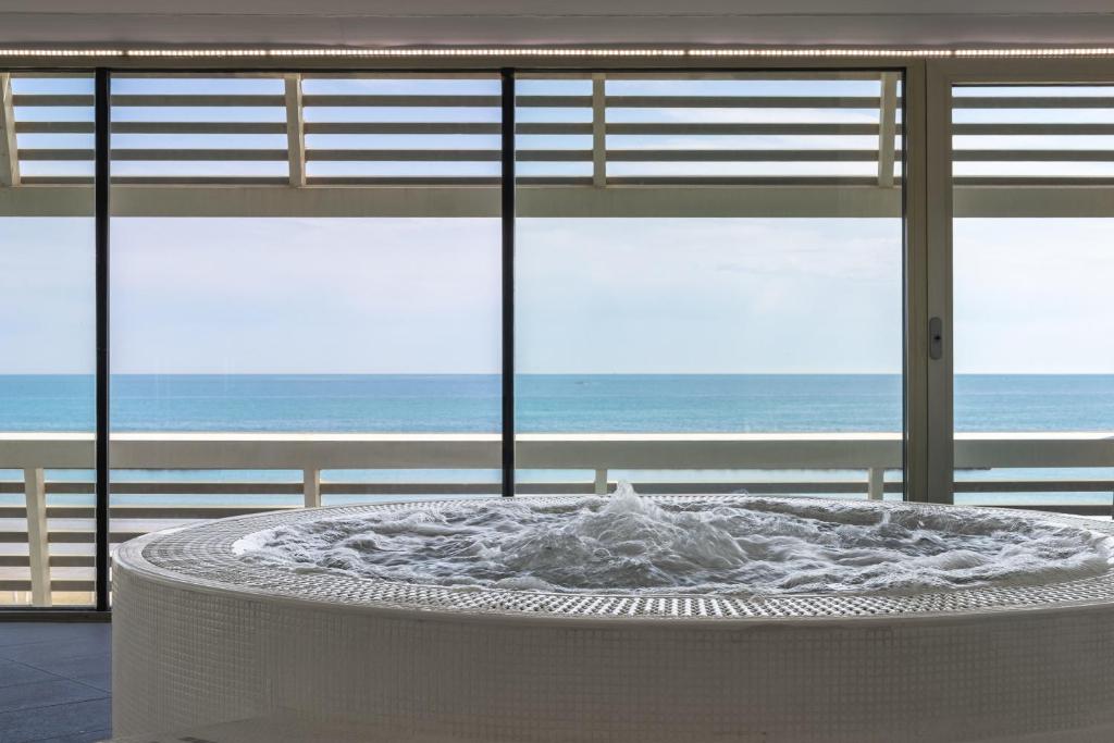 une grande table blanche avec vue sur l'océan dans l'établissement Excelsior Hotel, SPA & Lido - Preferred Hotels & Resorts, à Pesaro