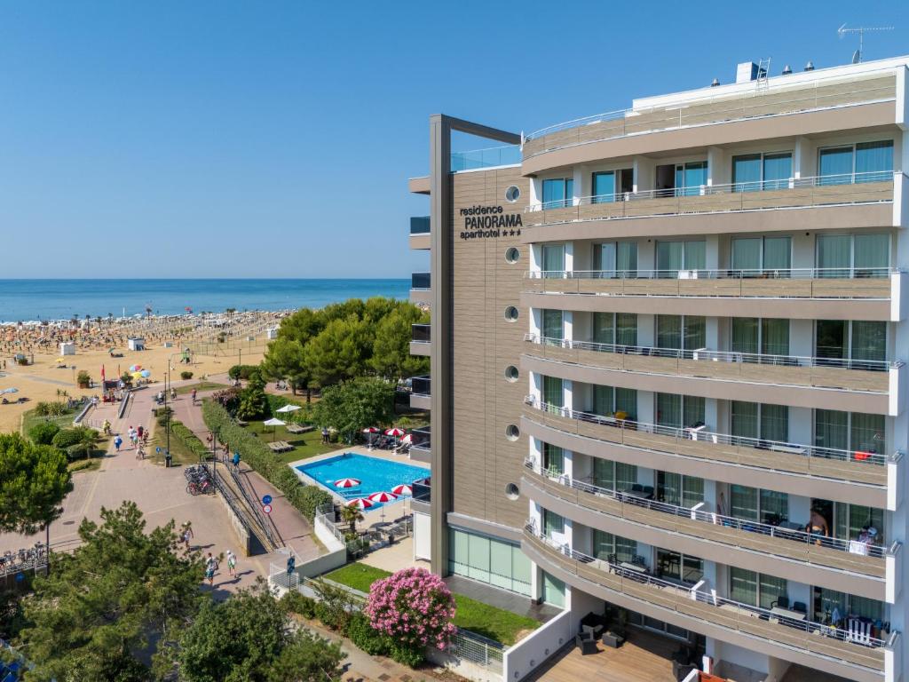 un hôtel avec une plage en arrière-plan dans l'établissement Residence Panorama Apart Hotel, à Bibione