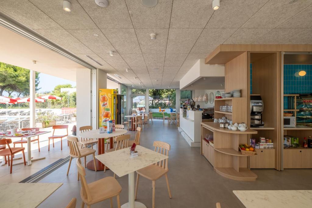 une cuisine et une salle à manger avec tables et chaises dans l'établissement Residence Panorama Apart Hotel, à Bibione