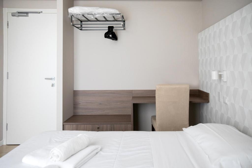 une chambre avec un lit blanc avec des serviettes dessus dans l'établissement Hotel Benvenuto, à Caorle