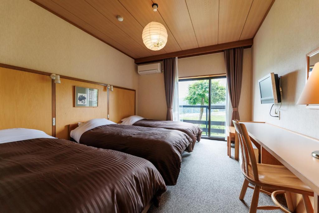 Cette chambre comprend 3 lits et un bureau. dans l'établissement Hotel Kikori, à Hida 37 autres photos