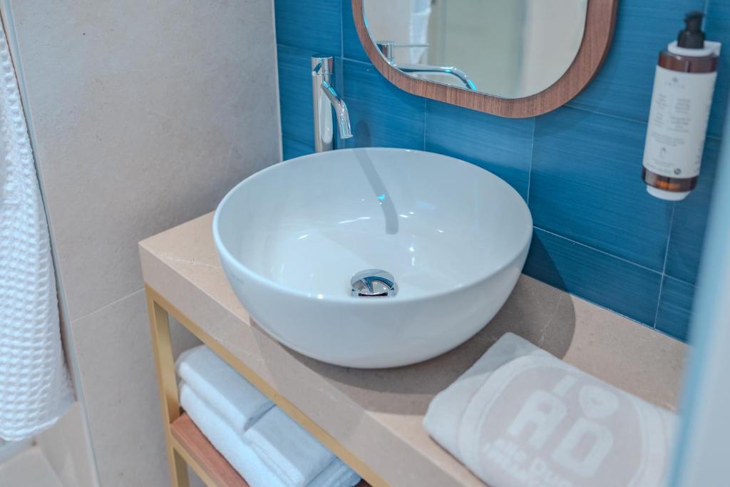 une salle de bain avec un lavabo blanc et un miroir dans l'établissement Tuscany Hotel Alle Dune, à Marina di Castagneto Carducci