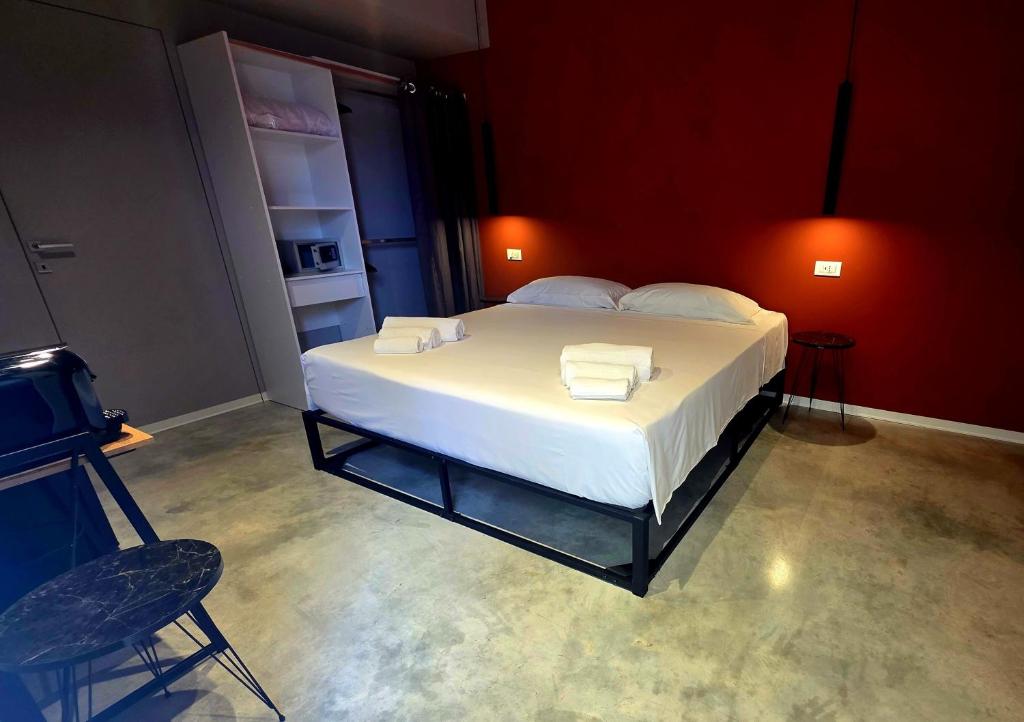 - une chambre dotée d'un grand lit avec des draps blancs et une chaise dans l'établissement Sottocoperta, à Roseto degli Abruzzi