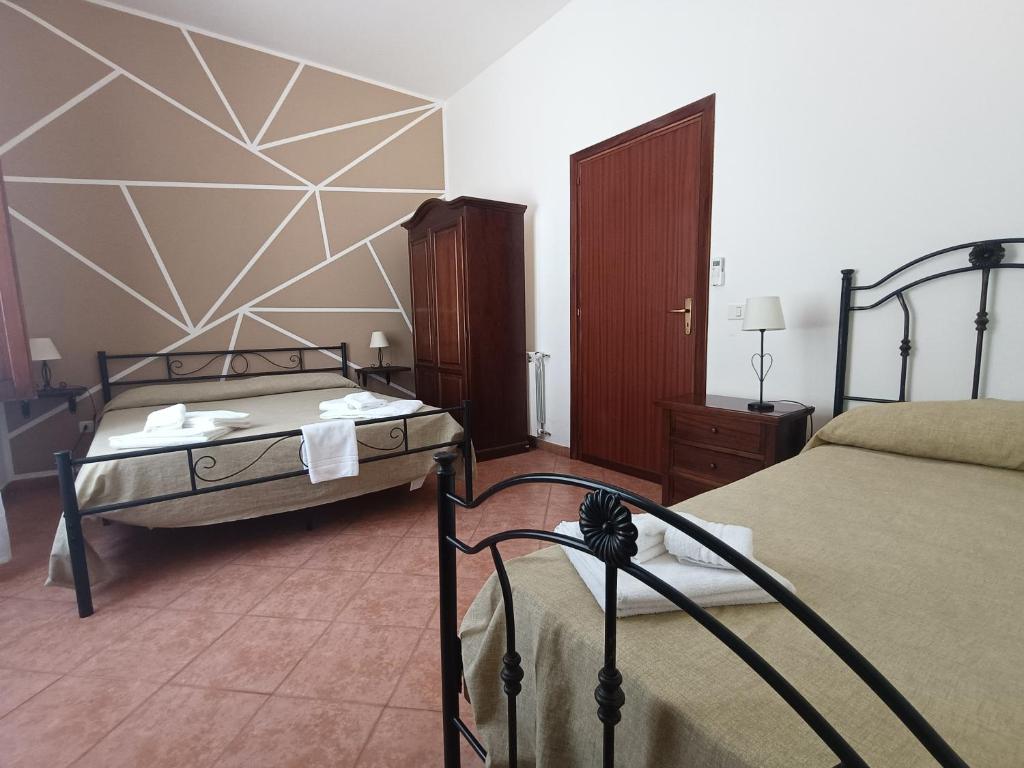 une chambre d'hôtel avec deux lits dans une chambre dans l'établissement Albergo diffuso Borgo Gallodoro da Sara, à Gallodoro