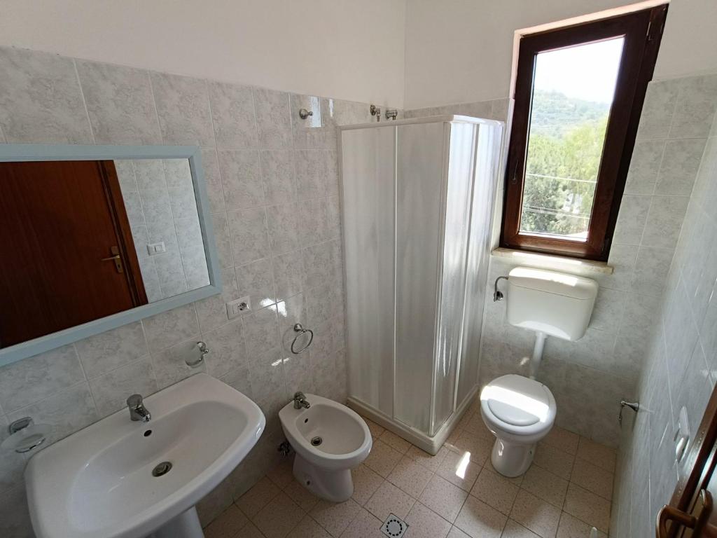une salle de bain avec un lavabo, des toilettes et une douche dans l'établissement Albergo diffuso Borgo Gallodoro da Sara, à Gallodoro