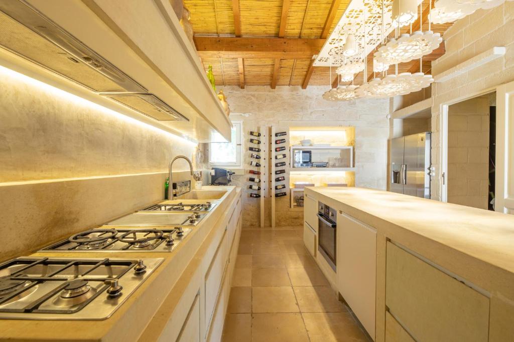 Il comprend une grande cuisine équipée d'une cuisinière et d'un évier. dans l'établissement Masseria Blanca Lapis, à Martano