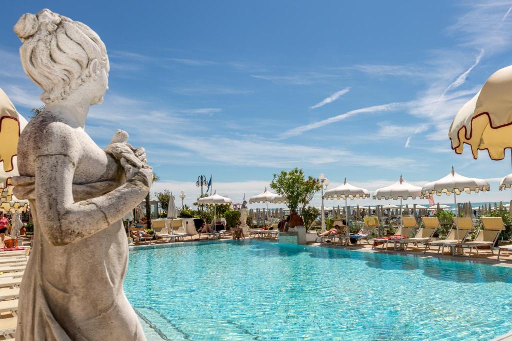 une statue en face d'une piscine dans un complexe dans l'établissement Luxor e Cairo The Beach Resort, à Lido di Jesolo