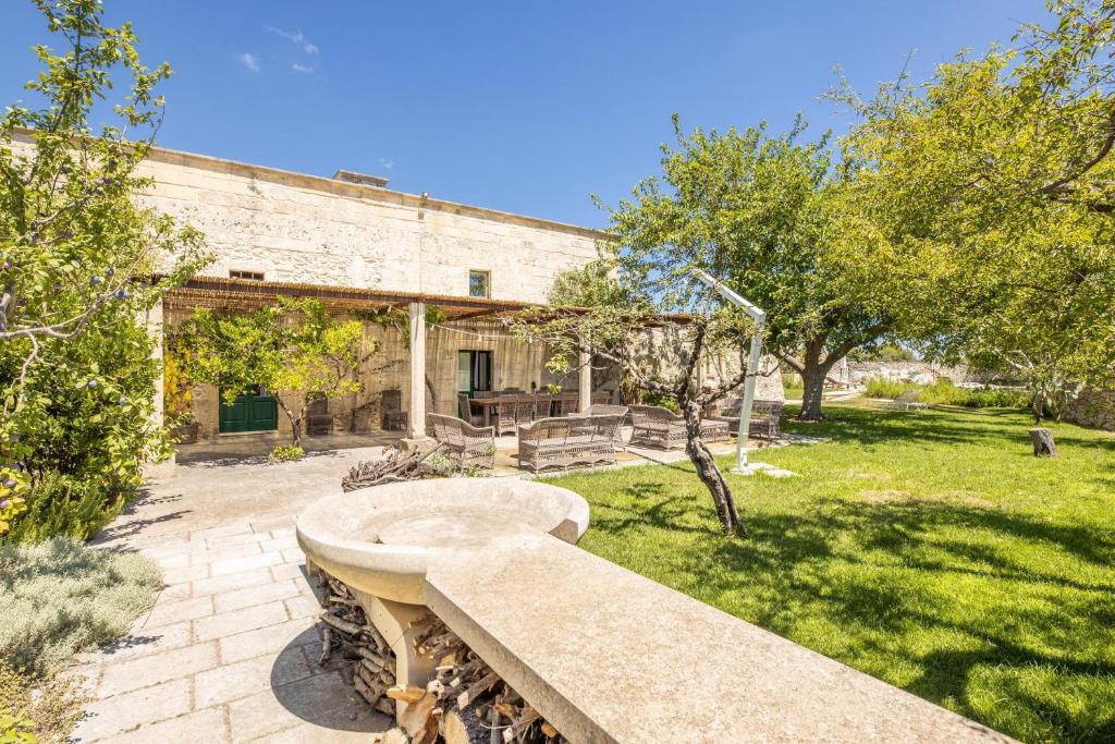 un bâtiment avec un banc en pierre dans une cour dans l'établissement Masseria Blanca Lapis, à Martano