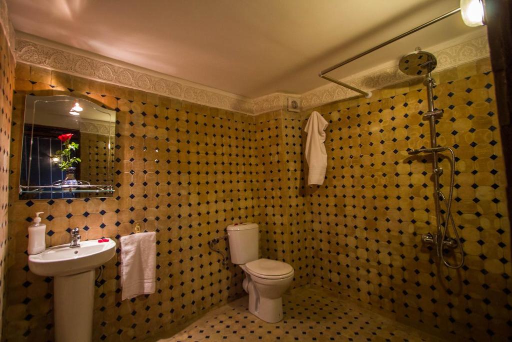 une salle de bain avec un lavabo, des toilettes et un miroir dans l'établissement Dar El Mathaf, à Fès 37 autres photos