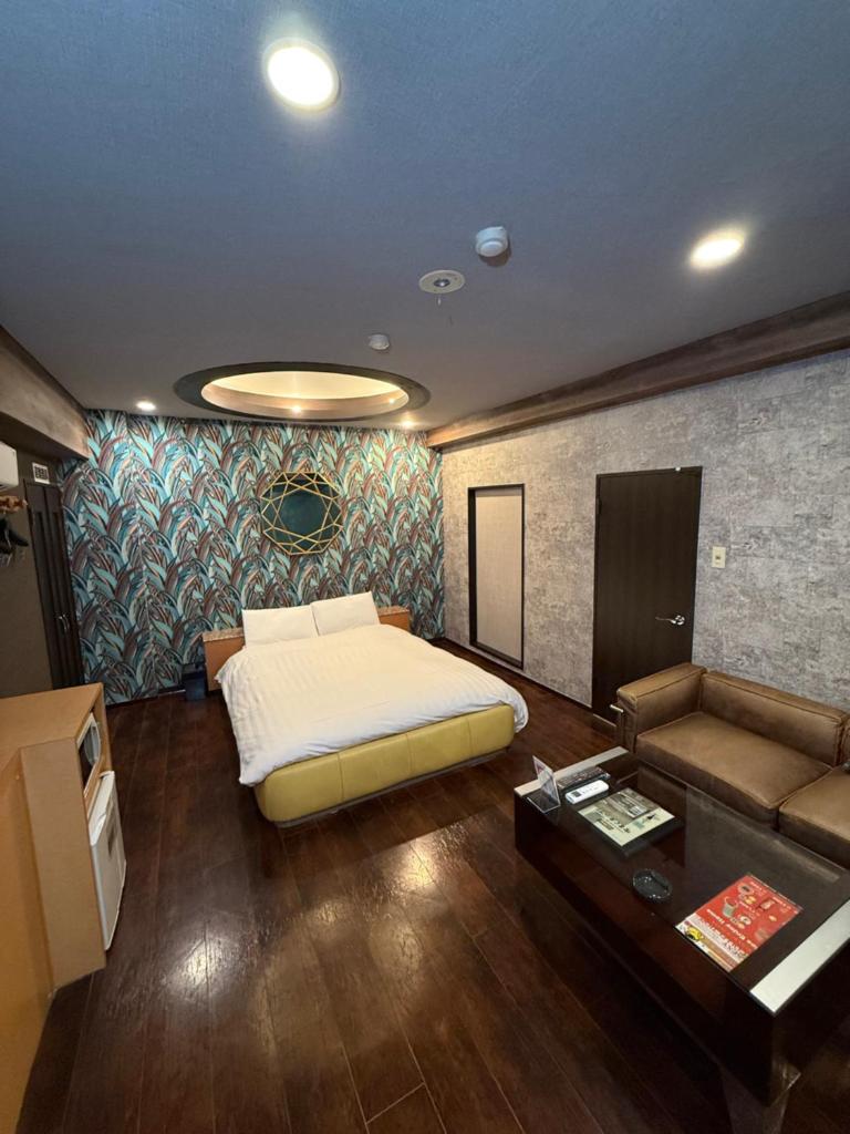 une chambre avec un lit, un canapé et une table dans l'établissement Nuda by H-Seven (Adult Only), à Yokohama