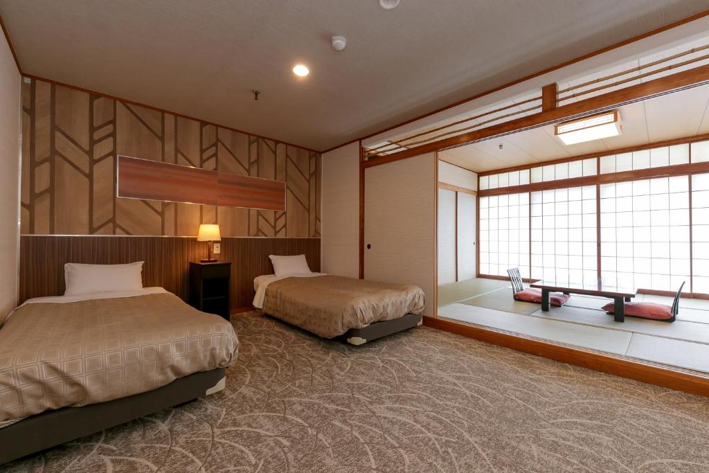 une chambre d'hôtel avec deux lits et une fenêtre dans l'établissement Kinugawa Royal Hotel, à Nikkō