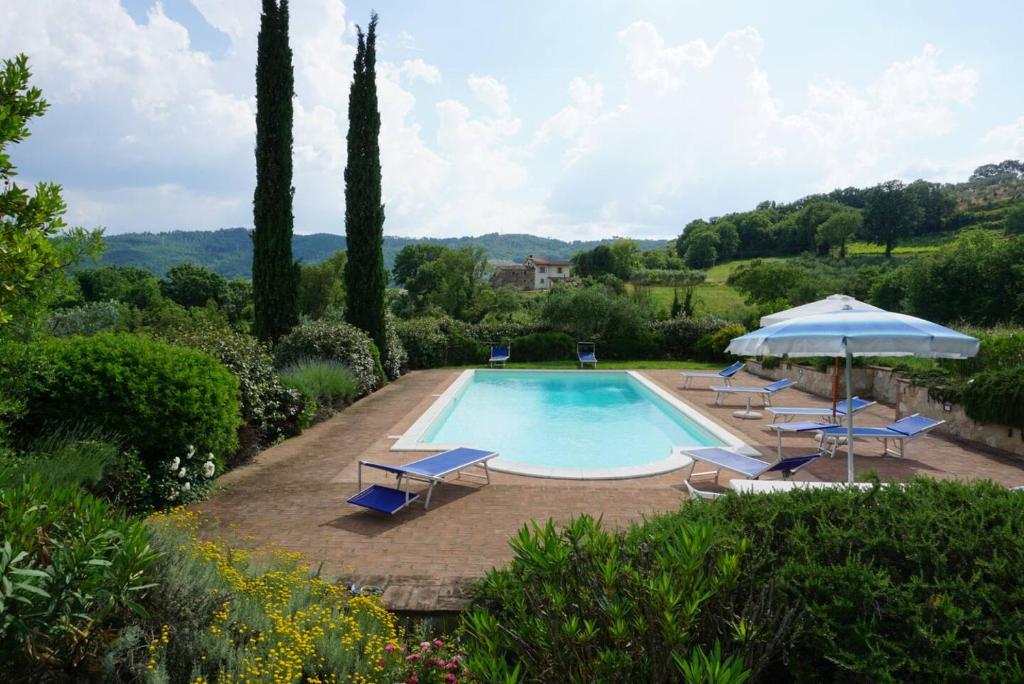 une piscine avec des chaises longues et un parasol dans l'établissement Antico Casale in pietra con Piscina privata, à Monte Molino