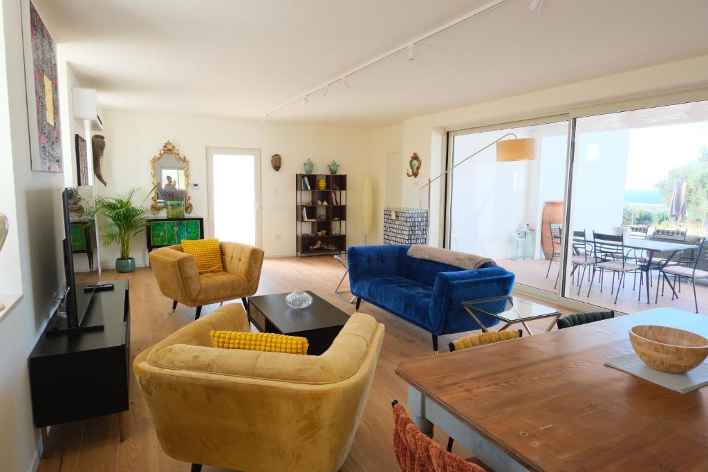 un salon avec un canapé bleu et des chaises dans l'établissement Villa Panorama, à Polignano a Mare