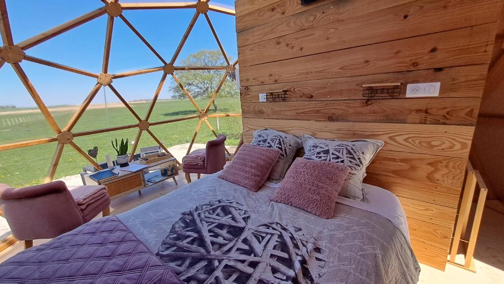 une chambre avec un lit et une grande fenêtre dans l'établissement A l'aube des sens, à Bailly-le-Franc