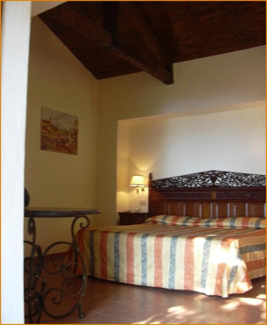 une chambre avec un lit dans le coin d'une pièce dans l'établissement illicini stabilimento balneare e albergo, à Maratea