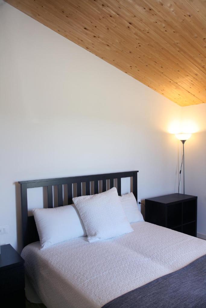 une chambre avec un lit avec un plafond en bois dans l'établissement Le Golfette - Ville al Golf, à Manerba del Garda 40 autres photos