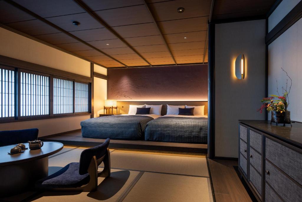 une chambre avec un lit, un bureau et une table dans l'établissement Osawayama Onsen Osawakan, à Minami Uonuma