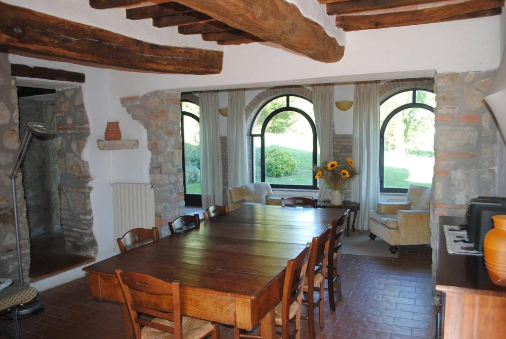 une salle à manger avec une grande table et des chaises en bois dans l'établissement Antico Casale in pietra con Piscina privata, à Monte Molino