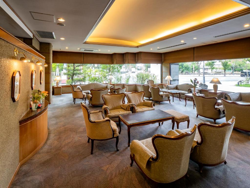une salle d'attente avec des chaises, des tables et des fenêtres dans l'établissement Hotel Fukiageso, à Kagoshima