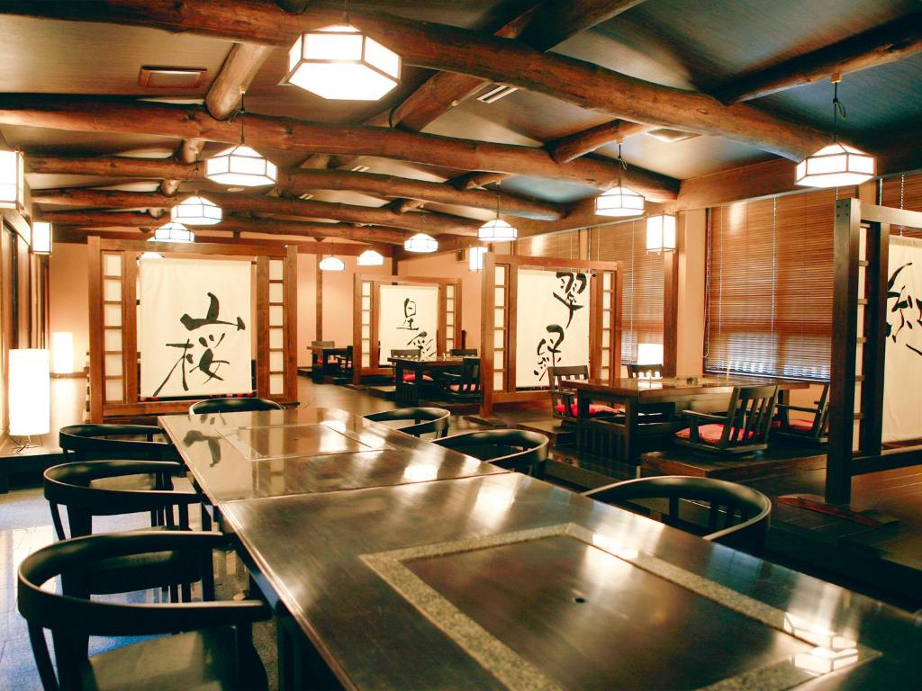 une grande salle avec des tables et des chaises dans un restaurant dans l'établissement Suikoen, à Kawanehon