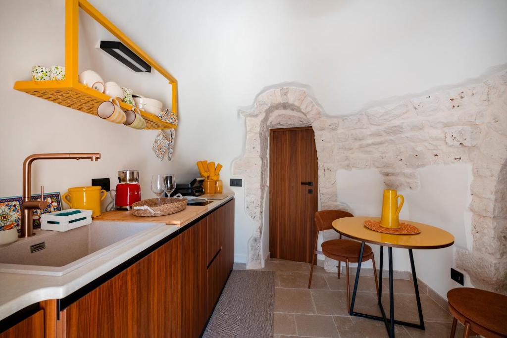 - une cuisine avec un évier et un comptoir avec une table dans l'établissement Dimora Dormio, à Monopoli