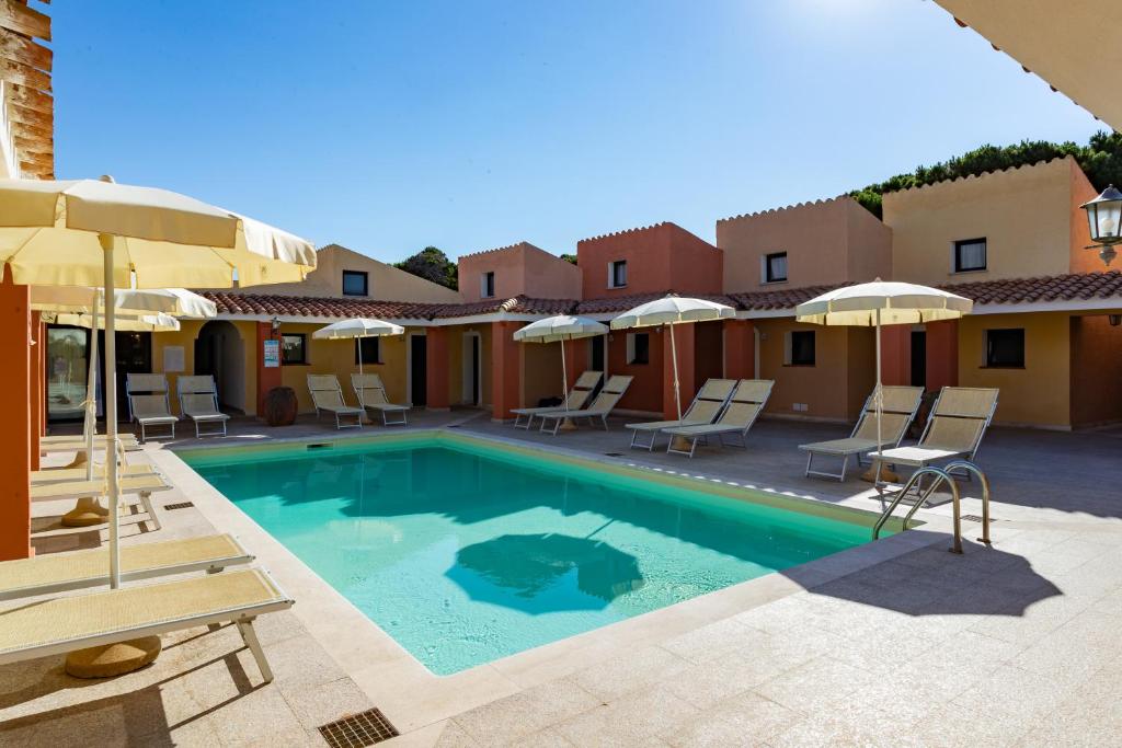 une piscine dans un hôtel avec des chaises et des parasols dans l'établissement Club Hotel Marina Seada Beach, à Budoni