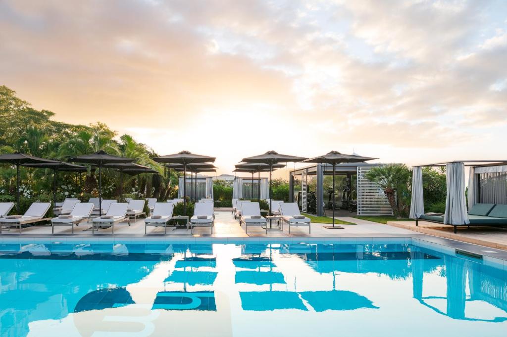 une piscine avec chaises longues et parasols dans l'établissement Hotel Mariver, à Lido di Jesolo 92 autres photos