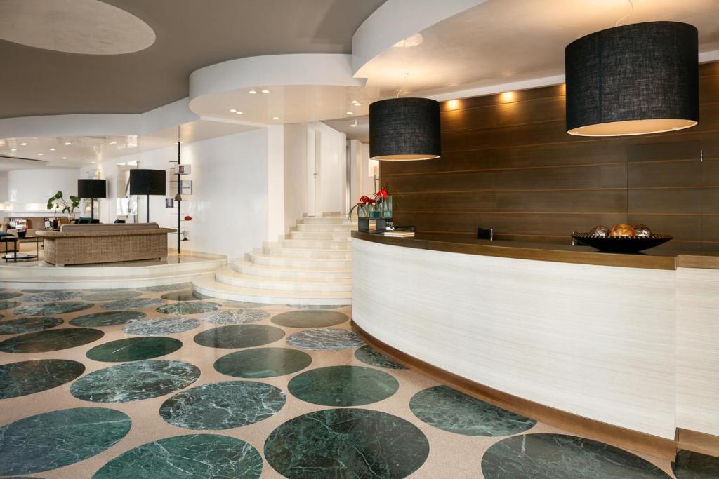 dans le hall de l'hôtel, vous trouverez un comptoir de réception et un escalier. dans l'établissement Hotel Mariver, à Lido di Jesolo