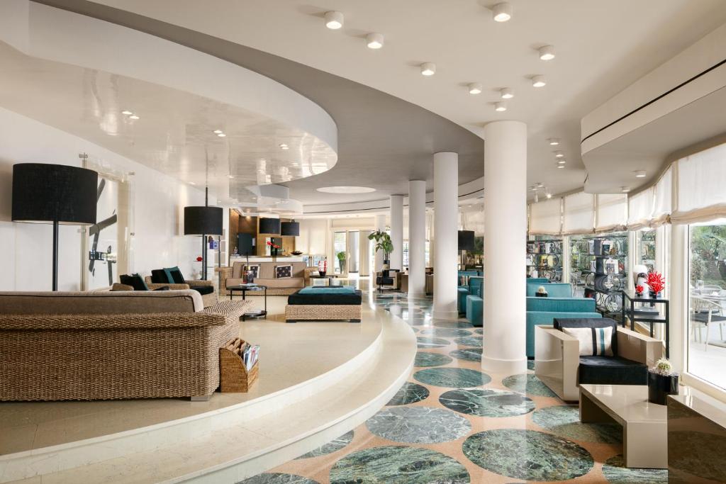 un hall d'entrée avec des canapés et des chaises dans un bâtiment dans l'établissement Hotel Mariver, à Lido di Jesolo