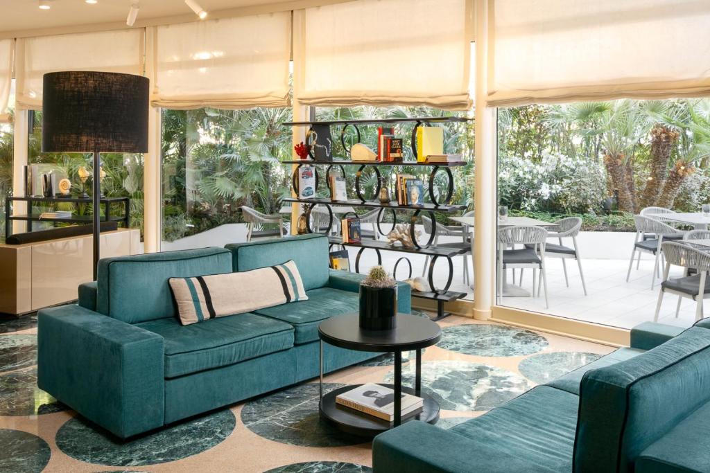 un salon avec deux canapés bleus et une table dans l'établissement Hotel Mariver, à Lido di Jesolo