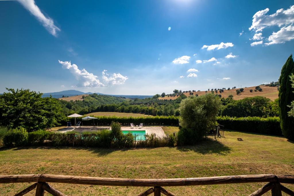 une vue d'une cour avec une piscine et une clôture dans l'établissement Scappo in Umbria, La dolce Godera, à Lugnano in Teverina