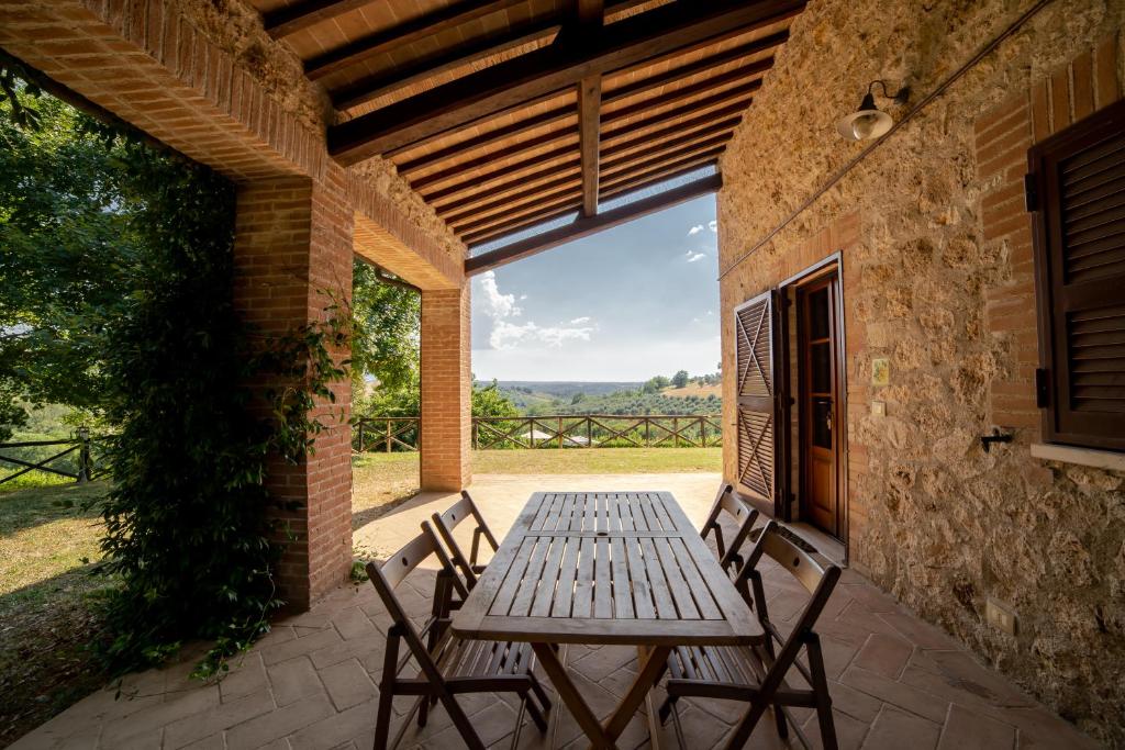 une table et des chaises en bois sur une terrasse dans l'établissement Scappo in Umbria, La dolce Godera, à Lugnano in Teverina