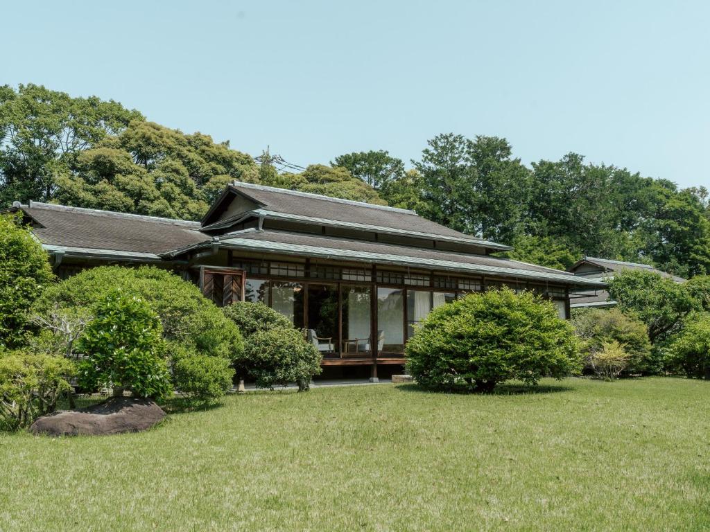 une grande maison avec des fenêtres en verre sur une cour dans l'établissement Sanyo-so, à Izunokuni