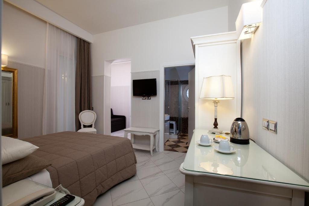 une chambre d'hôtel avec un lit et un bureau avec une lampe dans l'établissement Hotel Residence Villa Del Mare, à Rimini