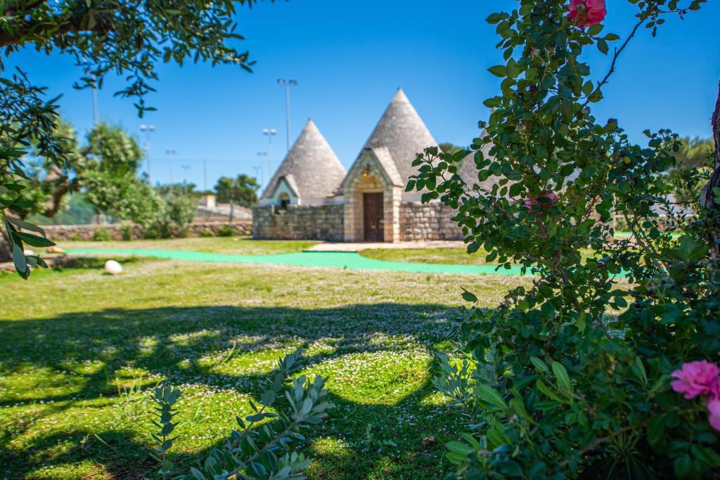 une maison avec un toit de chaume dans une cour dans l'établissement Porto Giardino - CDSHotels, à Monopoli