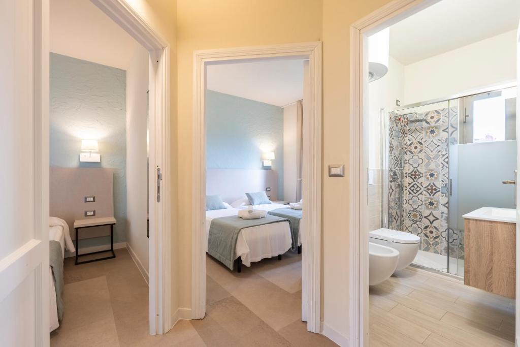 une chambre d'hôtel avec un lit et une salle de bain dans l'établissement Baia delle Mimose Hotel, à Codaruina