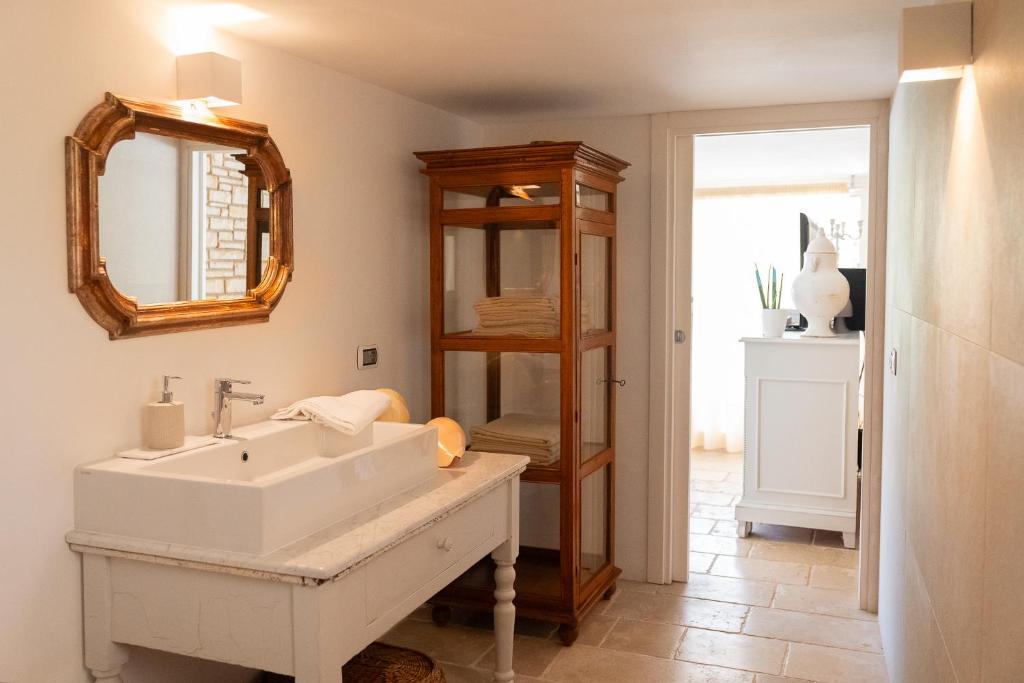 une salle de bain avec un lavabo blanc et un miroir dans l'établissement Villa Flora, à Depressa
