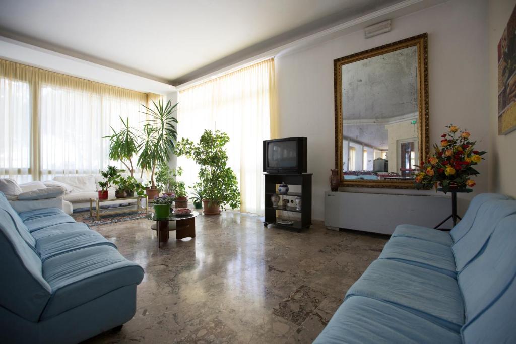 un salon avec des canapés bleus et un miroir dans l'établissement Hotel Europa, à Rimini