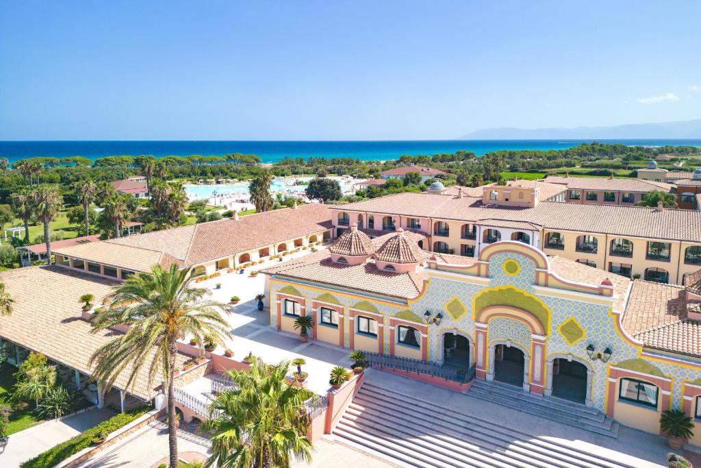 une vue aérienne d'un grand bâtiment avec des palmiers dans l'établissement Club Hotel Marina Beach, à Orosei