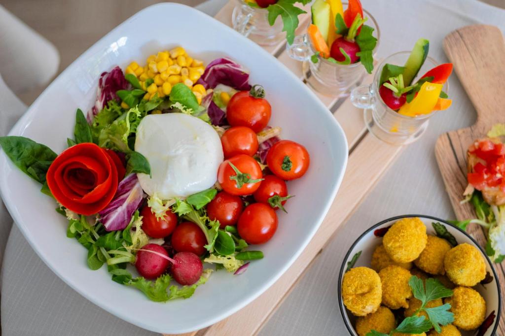 une assiette de salade et de tomates sur une table dans l'établissement Aura Living Hotel, à Rimini