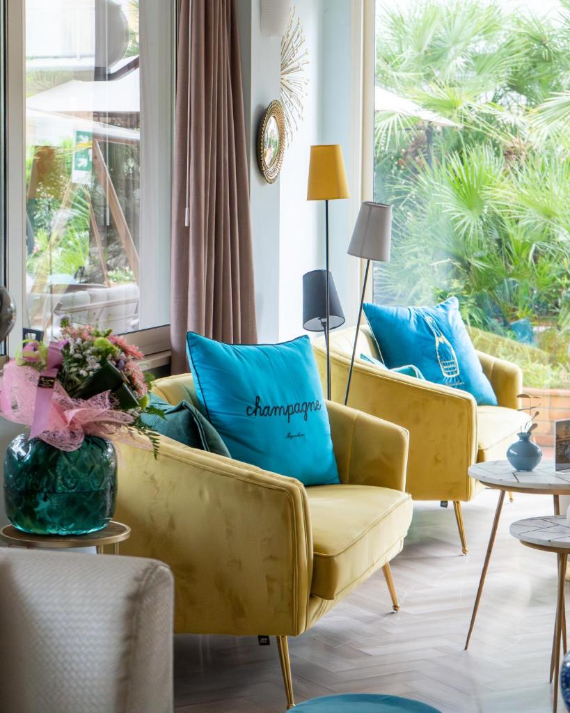 - un salon avec deux canapés jaunes et des oreillers bleus dans l'établissement Aura Living Hotel, à Rimini
