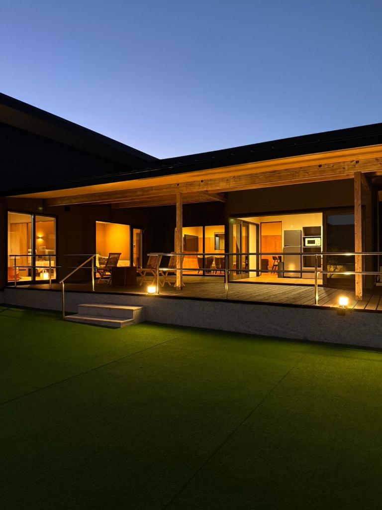 une maison avec une pelouse verte devant dans l'établissement Umine Annex, à Beppu