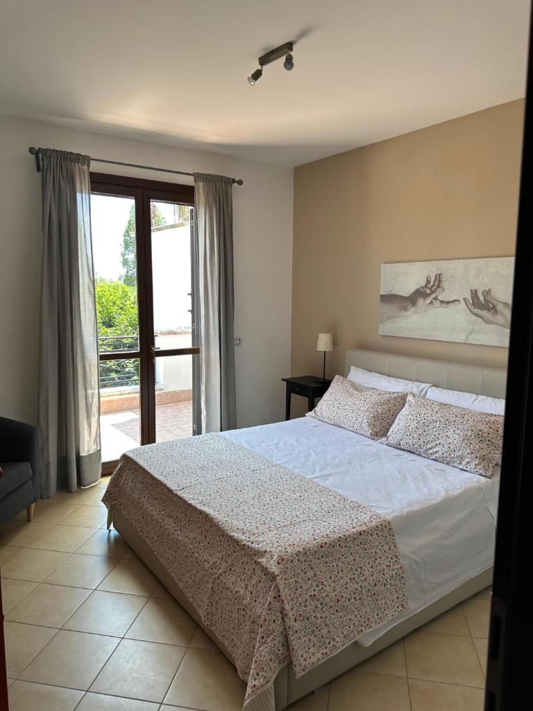 une chambre avec un grand lit et une fenêtre dans l'établissement Villa sole Sicily, à Terrasini