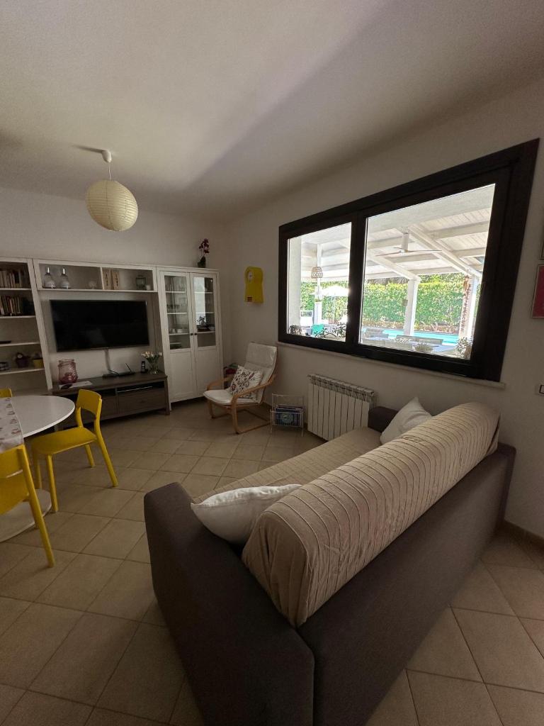 un salon avec un canapé et une grande fenêtre dans l'établissement Villa sole Sicily, à Terrasini