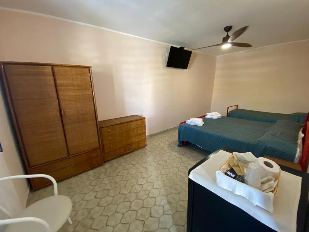 - une chambre avec un lit, une commode et une télévision dans l'établissement Cinquestelle Albergo del centro storico, à Palinuro 119 autres photos