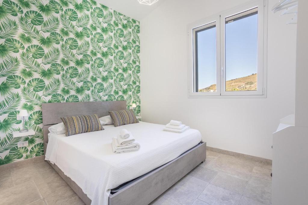 une chambre avec un lit avec un papier peint vert et blanc dans l'établissement Villa Aurora, à Balata di Baida 34 autres photos