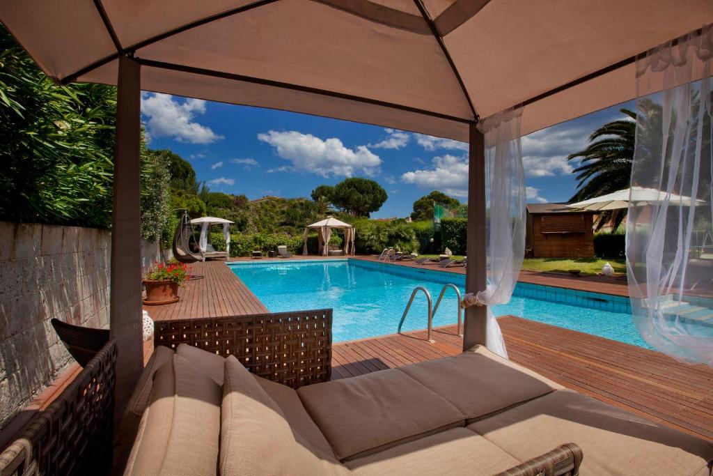 une terrasse avec un canapé et une piscine dans l'établissement Albaruja Hotel, à Costa Rei