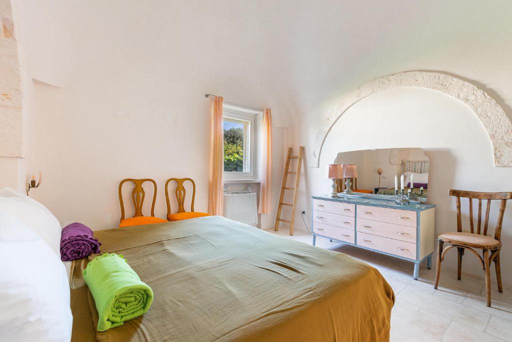 une chambre avec un lit, une commode et un miroir dans l'établissement Trulli Almaviva by Perle di Puglia, à Cisternino